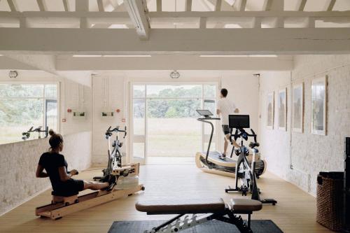 un gimnasio con varias personas haciendo ejercicio en cintas de correr en Fritton Lake - The Clubhouse, en Great Yarmouth