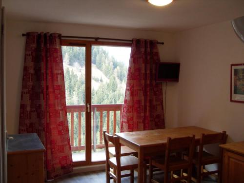 uma sala de jantar com uma mesa e uma grande janela em Appartement Valfréjus, 3 pièces, 6 personnes - FR-1-265-250 em Valfréjus