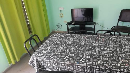 a bedroom with a bed and two chairs and a television at La Trinidad San Luis, La Punta in La Punta