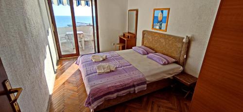 a bedroom with a bed with two towels on it at Apartments Abramovic 2 in Sutomore