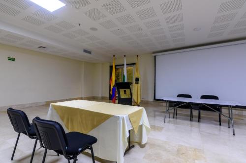a room with a table and chairs and a white screen at Hotel Dorado La 70 in Medellín