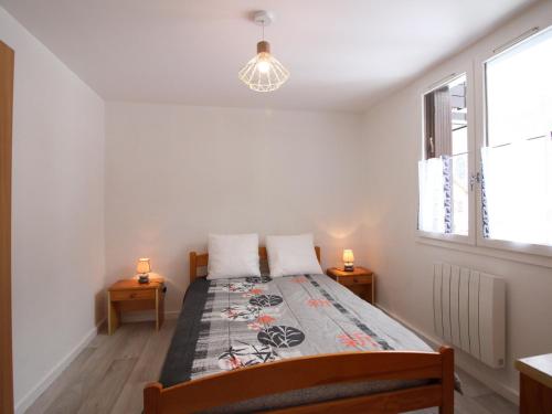 une chambre avec un lit avec deux lampes sur deux tables dans l'établissement T2 Mont-Dore 32m², Ascenseur, Parking, Calme, Proche Centre & Thermes - FR-1-608-91, à Le Mont-Dore