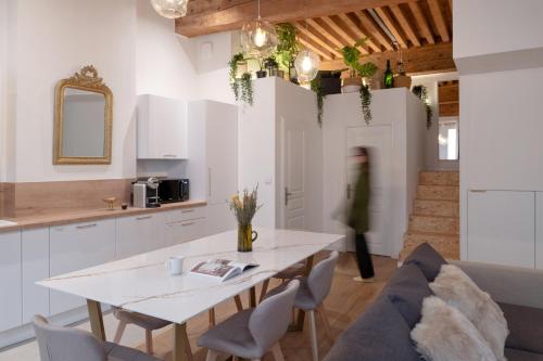 a kitchen and living room with a table and a couch at MiHotel Georges in Lyon
