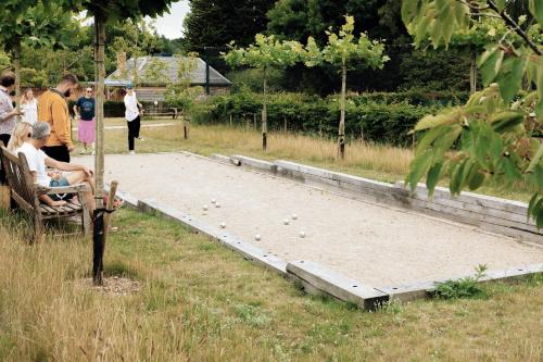 people are sitting on a bench in a park at Fritton Lake - The Clubhouse in Great Yarmouth