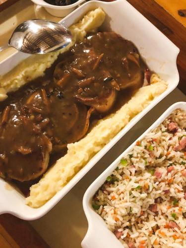 a tray of food with rice and meat and gravy at Pousada e Bistrô Estância Monte Horebe in Mulungu