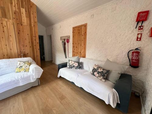 a living room with two white couches and a wall at Vacas Felizes Villas - Casa da Bilha in Rabo de Peixe