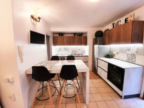 uma cozinha com uma mesa e algumas cadeiras pretas em Villa D'Amare em Riccione