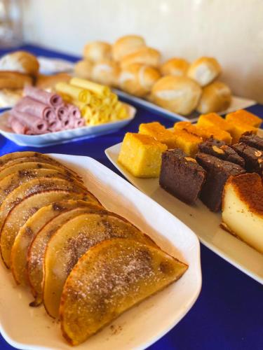 a table topped with plates of pastries and other foods at Pousada e Bistrô Estância Monte Horebe in Mulungu