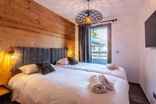 une chambre avec deux lits et une fenêtre dans l'établissement ECHO DU PLENEY A 104, à Morzine