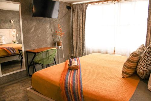 a bedroom with a bed and a table and a mirror at Casa Flora Handmade Hotel in Atlixco