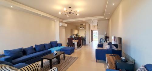 a living room with blue couches and a table at Ain Sokhna 'Cosmopolitan'- Half-Board in Ain Sokhna