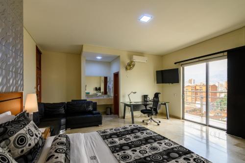 a hotel room with two beds and a living room at Hotel Dorado La 70 in Medellín