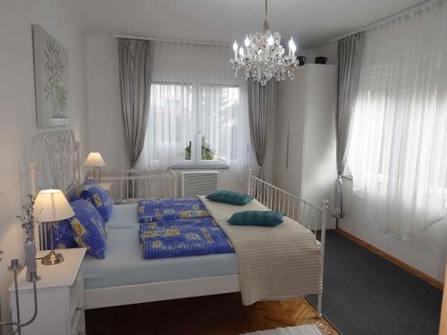 フォニョードにあるHoliday home in Fonyod/Balaton 18626のベッドルーム1室(青い枕とシャンデリア付きのベッド1台付)