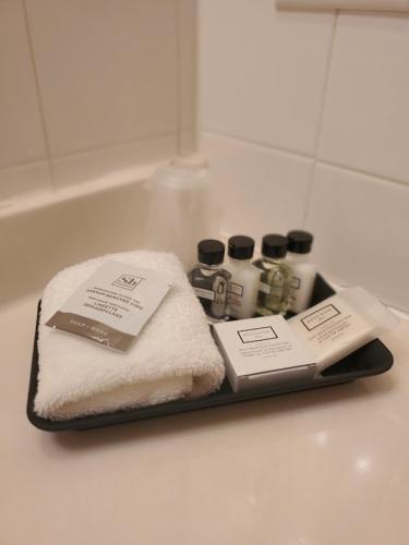 a tray with towels and other items on a bathroom counter at Three Forks Lewis & Clark Motel in Three Forks