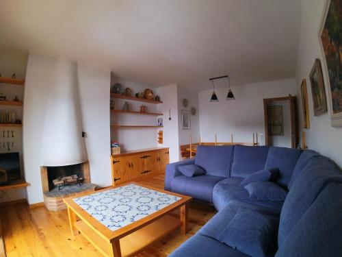 a living room with a blue couch and a coffee table at Soldeu Paradis Soldeu in Soldeu