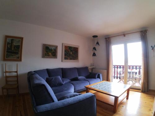 a living room with a blue couch and a table at Soldeu Paradis Soldeu in Soldeu