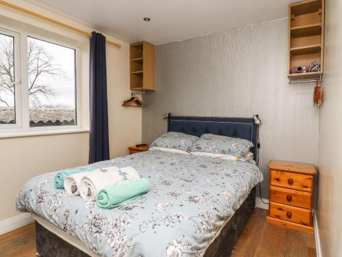 een slaapkamer met een bed met handdoeken erop bij The Old Piggery in Keighley