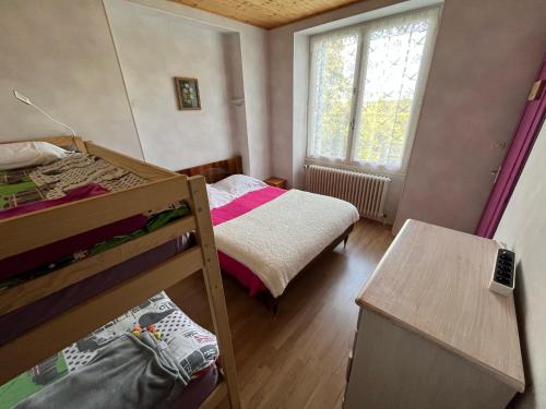 a bedroom with two bunk beds and a window at Entre mûres et châtaignes in Les Châtelliers-Châteaumur