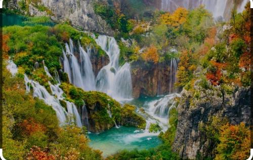 a waterfall in the middle of a mountain with trees at Holiday house "Mimoza" 2 massage pools in Otočac