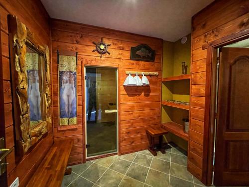 La salle de bains est pourvue de murs en bois et d'une douche avec une porte en verre. dans l'établissement Villa Fort Tenerife, à Tacoronte