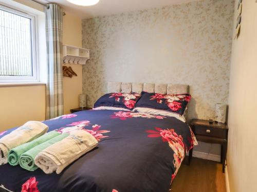 - une chambre avec un lit fleuri dans l'établissement The Old Hen Shed, à Ingrow