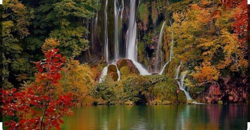 a waterfall in the middle of a lake with trees at Holiday house "Mimoza" 2 massage pools in Otočac
