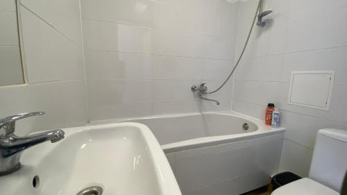 a bathroom with a tub and a sink and a toilet at Apartment City Center in Klaipėda