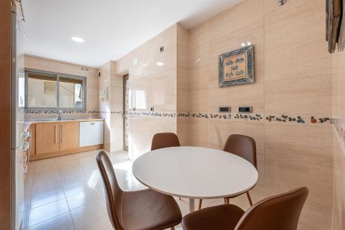 uma sala de jantar com uma mesa branca e cadeiras em 797 HOLIDAY RENTALS - BELLAGIO- Elegante piso para 6 a 1 min de la playa, con piscina interior y exterior, SPA con jacuzzi em Benalmádena