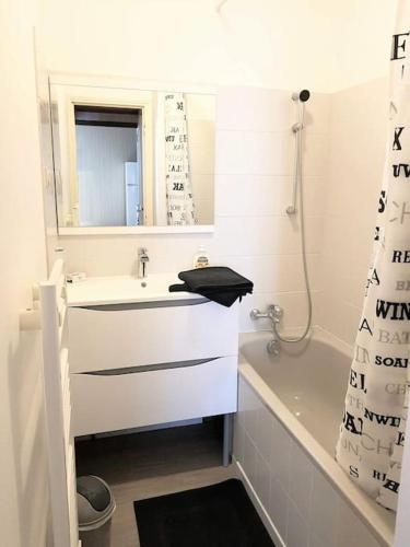 une salle de bain avec un lavabo, un miroir et une baignoire dans l'établissement Le Refuge Des Corderies, à Blois