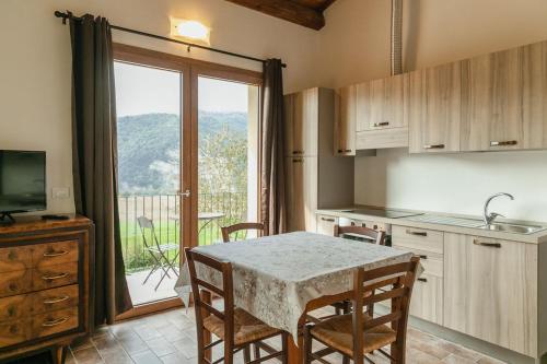 a kitchen with a table with chairs and a large window at PODERE PIANA in Carseggio