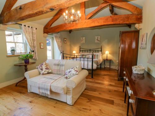 ein Wohnzimmer mit einem Sofa und einem Bett in der Unterkunft The Cartshed, Sedbury Park Farm in Gilling
