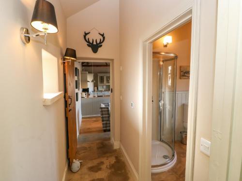 a bathroom with a walk in shower and a toilet at The Cartshed, Sedbury Park Farm in Gilling