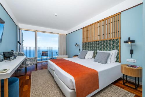 a hotel room with a bed and a view of the ocean at Hotel Quinta Do Furao in Santana
