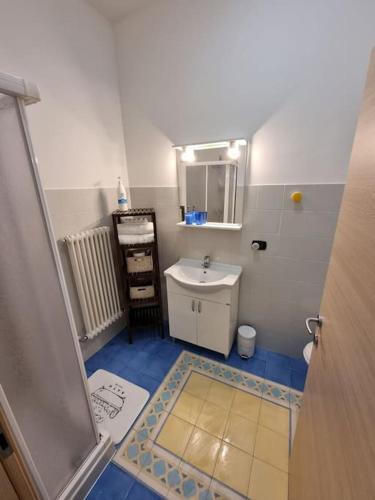 a small bathroom with a sink and a mirror at Apartments via Roma in Rovereto