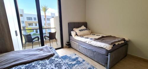 a small bedroom with a bed and a balcony at Ain Sokhna 'Cosmopolitan'- Half-Board in Ain Sokhna