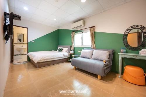 a bedroom with a bed and a couch and a mirror at 蒲Going旅宿 in Xiaoliuqiu