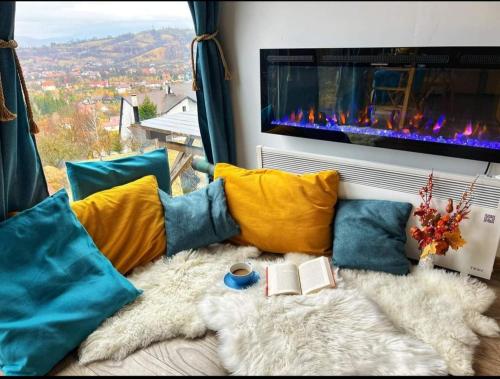 sala de estar con sofá con almohadas y chimenea en Tiny House Retreat Bran, en Bran