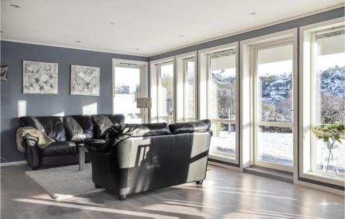 a living room with black leather furniture and windows at 4 Bedroom Cozy Home In Fitjar in Fitjar