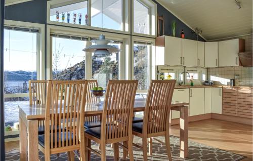 a kitchen with a wooden table and chairs and a dining room at 4 Bedroom Cozy Home In Fitjar in Fitjar