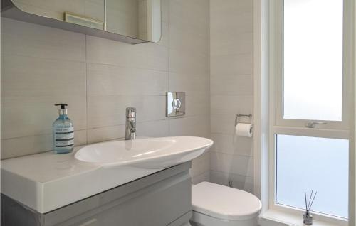 a white bathroom with a sink and a toilet at 4 Bedroom Cozy Home In Fitjar in Fitjar