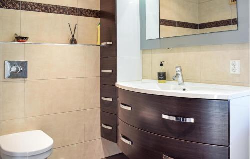 La salle de bains est pourvue d'un lavabo et de toilettes. dans l'établissement 4 Bedroom Cozy Home In Fitjar, à Fitjar