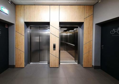 un couloir avec des portes d'ascenseur dans un immeuble dans l'établissement Primavera - Apartament nad rzeką - parking w cenie, à Wrocław