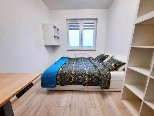 niewielka sypialnia z łóżkiem i oknem w obiekcie Primavera - Apartament nad rzeką - parking w cenie we Wrocławiu