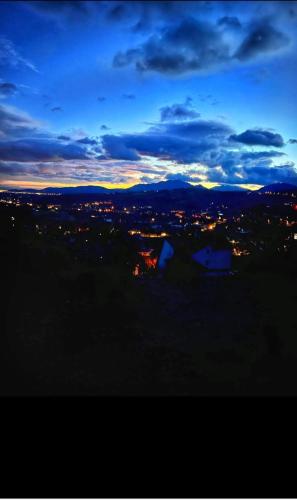 a view of a city lit up at night at Tiny House Retreat Bran in Bran