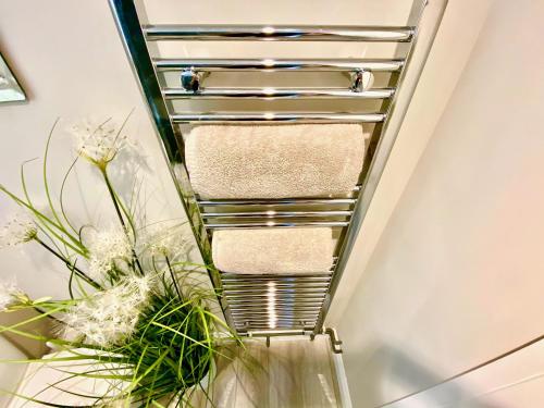 a towel rack in a bathroom with flowers at Sunridge Cubes (Cube 2) in Plymouth