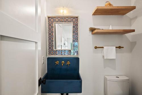 a bathroom with a blue chair and a mirror at Zen-N-Sea - 4222 Third St in Saint Simons Island