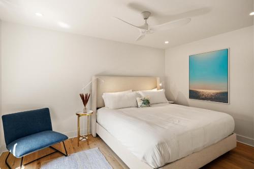 a bedroom with a bed and a blue chair at Zen-N-Sea - 4222 Third St in Saint Simons Island