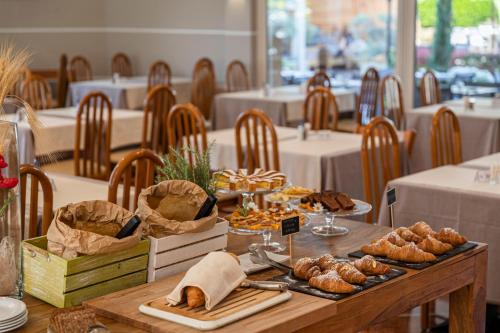 a table with bread and pastries on it in a restaurant at Hotel Imperial ***S in Garda