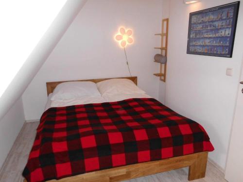 uma cama xadrez vermelha e preta num quarto em Koni-s-Hus-2 em Ording