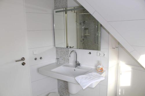 uma casa de banho branca com um lavatório e um WC em Koni-s-Hus-2 em Ording